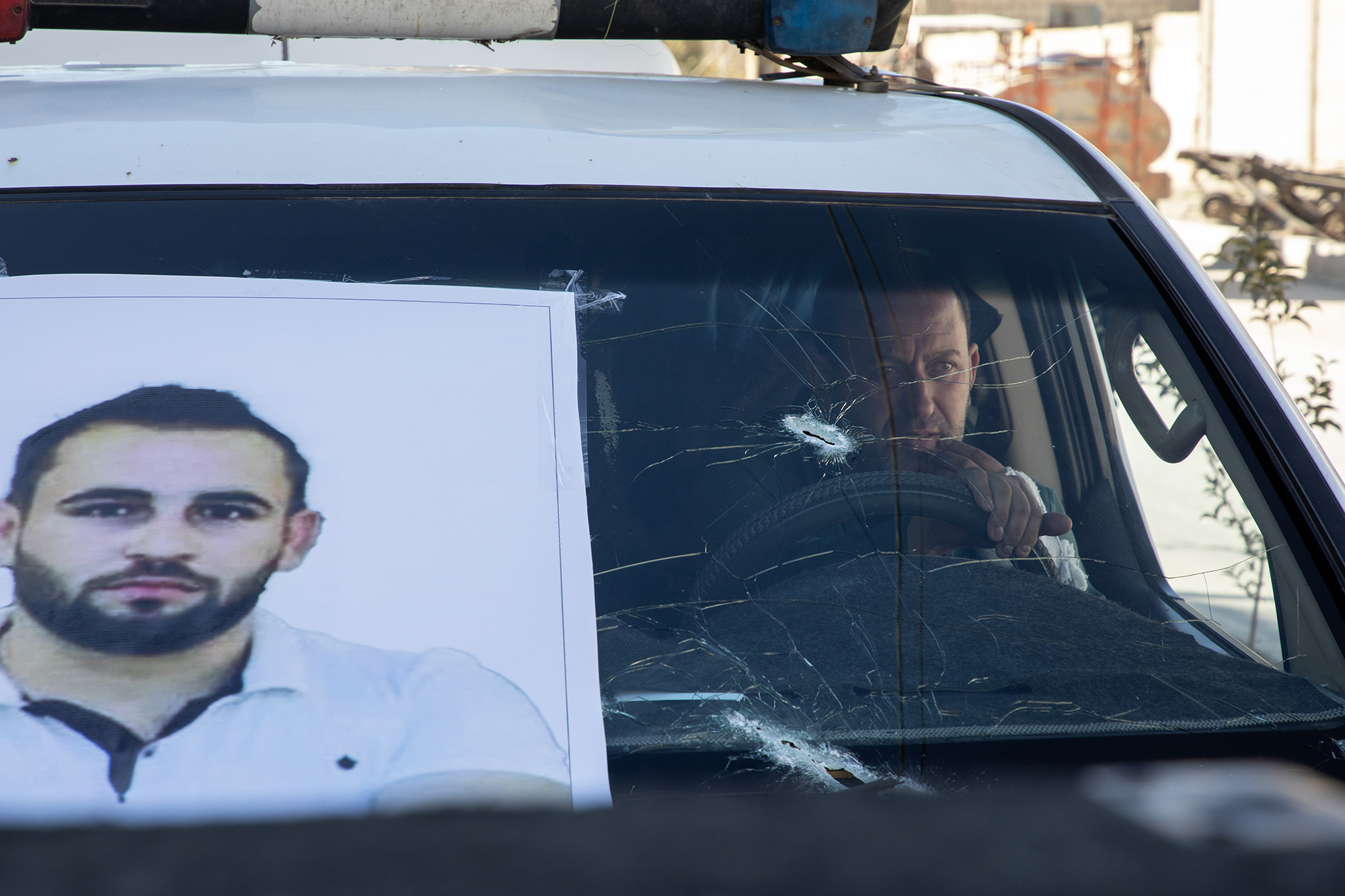 Kurdo Hesen, who was also injured, transports Mahir's coffin in an ambulance damaged in the attack alongside four others to Kobane cemetery. As with every funeral in the city, a long line of cars follows them to the cemetery, where thousands gather to pay their respects.