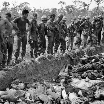 U.S. soldiers of the 3rd Brigade, 4th Infantry Division, look on a mass grave after a day-long battle against the Viet Cong 272nd Regiment, about 60 miles northwest of Saigon, in March 1967.