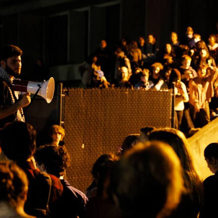 Amherst, MA - October 25: A protester leads students in a chant as they wait outside of Whitmore Administrative Building for their fellow protesters to be marched out of the building by police as students who staged a sit-in outside of the Chancellor's office were arrested for trespassing at University of Massachusetts Amherst. Students demanded that the Chancellor to end what they called, "UMass Amherst's ties with war profiteers and call for a ceasefire and end of the blockade on Gaza". (Photo by Jessica Rinaldi/The Boston Globe via Getty Images)