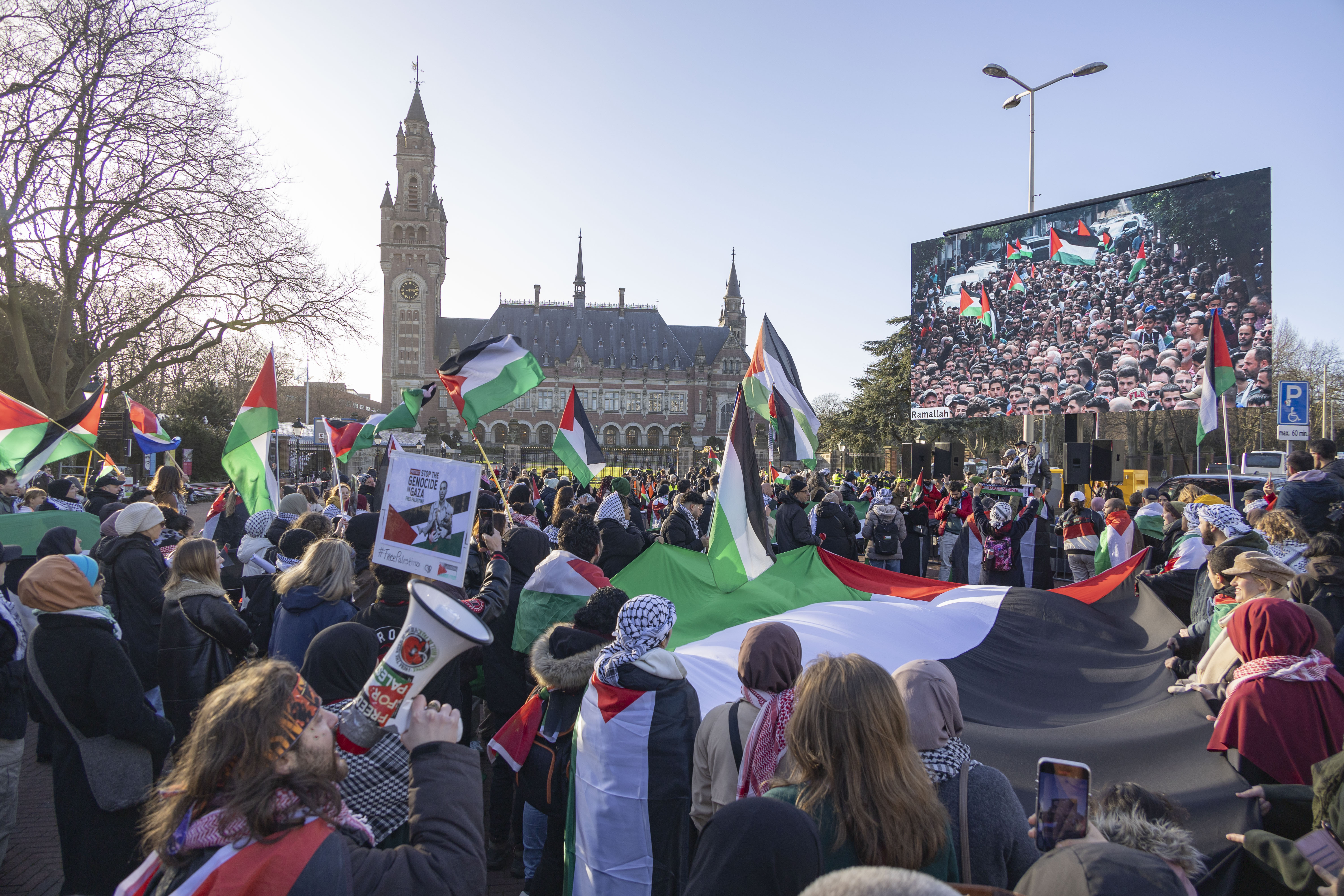 HAGUE, NETHERLANDS - JANAURY 26: People, holding Palestinian flags, gather outside the International Court of Justice during the session on the day the International Court of Justice (ICJ) rule on Gaza genocide case against Israel made by South Africa in the Hague, the Netherlands on January 26, 2024. The Peace Palace of the International Court of Justice was surrounded by journalists and protesters awaiting the court's interim ruling. The International Court of Justice (ICJ) announced its decision regarding the request for interim measures in the case. (Photo by Nikos Oikonomou/Anadolu via Getty Images)