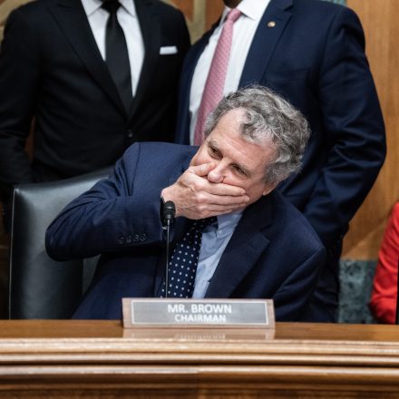 UNITED STATES - MARCH 7: Chairman Sherrod Brown, D-Ohio, reacts to his own voice while audio of a markup is accidentally played, during the Senate Banking, Housing and Urban Affairs Committee hearing titled "The Semiannual Monetary Policy Report to the Congress," featuring testimony by Federal Reserve Chairman Jerome Powell in Dirksen Building on Thursday, March 7, 2024. Ranking member Sens. Tim Scott, R-S.C., right, and Raphael Warnock, D-Ga., also appear. (Tom Williams/CQ-Roll Call, Inc via Getty Images)