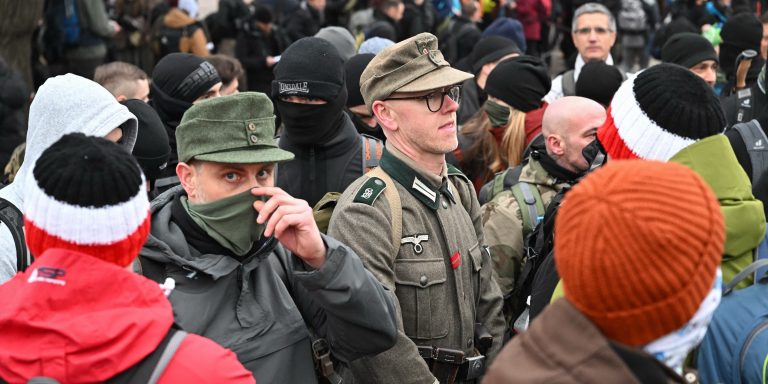 Participants wearing face coverings and military attile gather for an annual "memorial hike" of Hungarian and foreign participants of several neo-Nazi groups in Budapest on February 8, 2025. Hungarian police were on alert on February 8 ahead of divisive annual WWII-linked events in Budapest that sparked violence between neo-Nazis and anti-fascist activists in the past. European far-right groups gather in Budapest each year for the so-called "Day of Honour" to mark a failed attempt by Nazi and Hungarian troops in 1945 to break out of the city during the Soviet army's siege. (Photo by Attila KISBENEDEK / AFP) (Photo by ATTILA KISBENEDEK/AFP via Getty Images)
