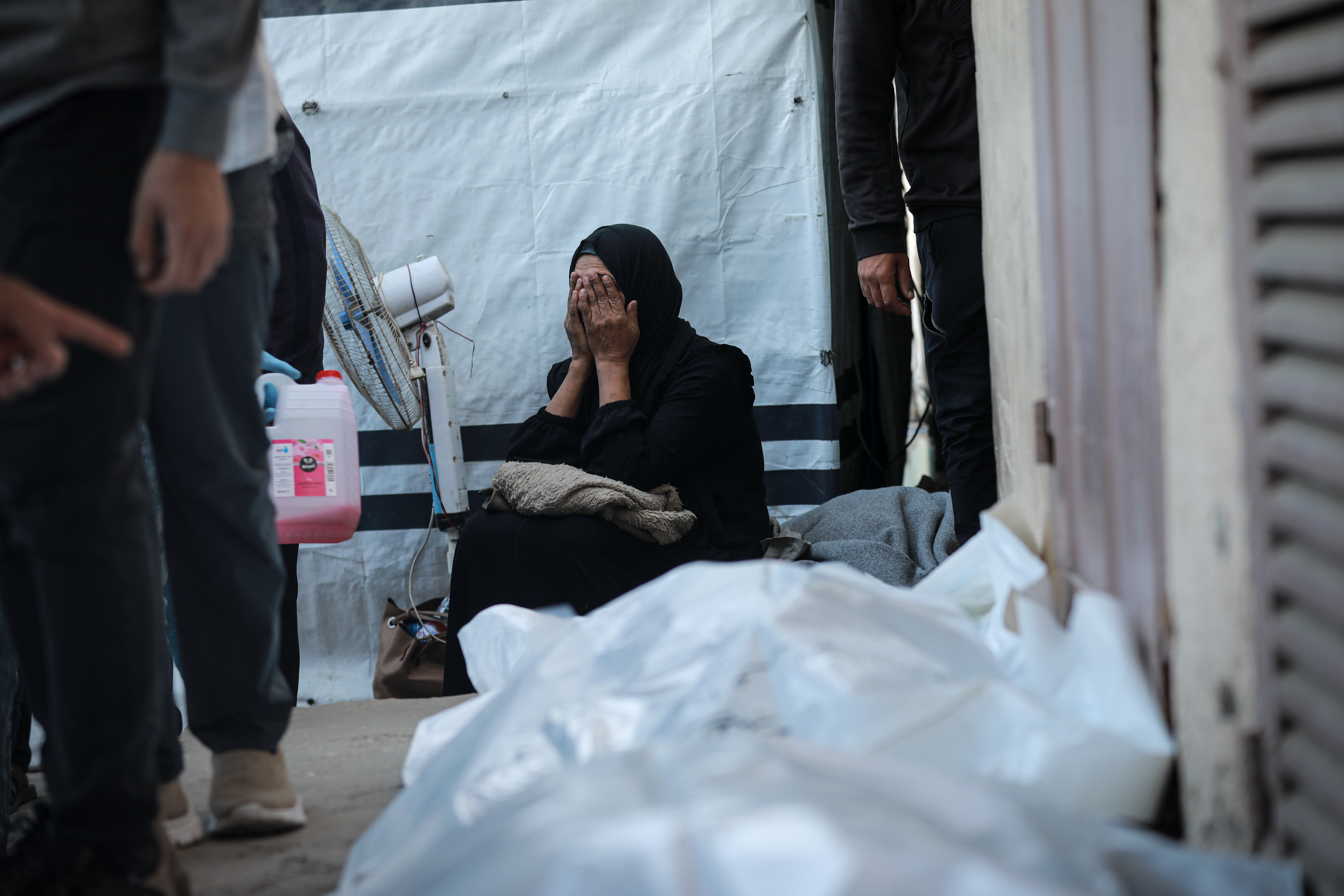 DEIR AL-BALAH, GAZA - NOVEMBER 23: Relatives of Palestinians, who lost their lives in Israeli attacks that violated the ceasefire across several areas of the Gaza Strip, mourn during the funeral which held at the Aqsa Martyrs Hospital in Deir al-Balah, Gaza on November 23, 2025. (Photo by Abdalhkem Abu Riash/Anadolu via Getty Images)